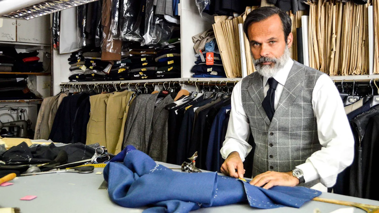 Sastre profesional reparando un traje azul en Tijuana